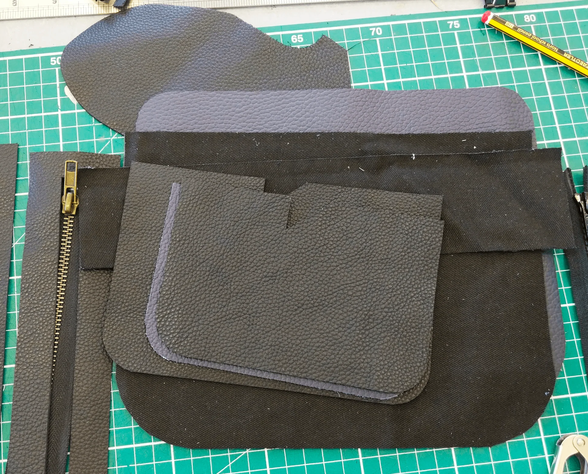 Leather bag panels laid out with zipper before assembly